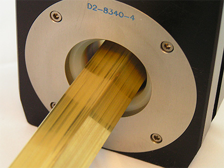 Eddy current probe testing brass bar stock for flaws and production seams